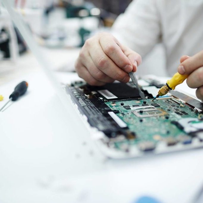 Man Repairing Circuit Board in Laptop